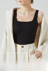 Détail du haut en tricot noir à col carré porté sous un blazer élégant de couleur crème
