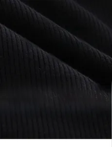 Close-up of black ribbed knit fabric showing elastic texture and moisture-wicking fibers
