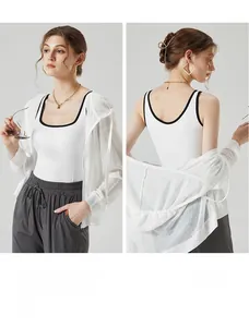 Détail du sweat à capuche en mesh blanc et débardeur contrasté avec jogging gris