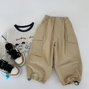 Flat lay of boys' khaki cargo pants with side pockets and a grey cartoon dog t-shirt