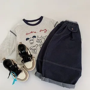 Tenue garçon avec t-shirt gris à motif chien, jean large bleu foncé et baskets mode