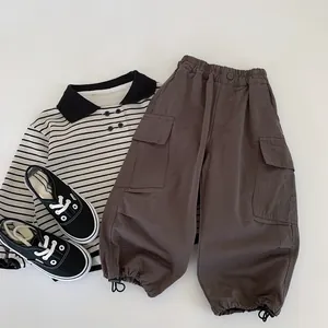 Flat lay of boys cotton polo shirt with striped pattern and cargo pants with side pockets