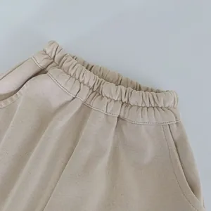 Détail de la taille élastique et des coutures sur le pantalon en tricot beige enfant