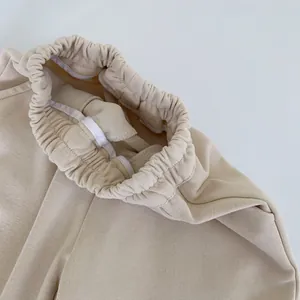 Détail de la large taille élastique et des coutures renforcées du pantalon de jogging beige