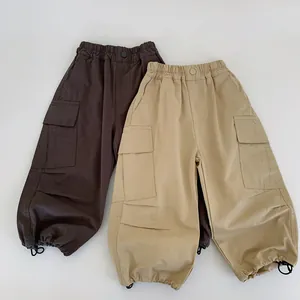 Detail of boys cargo pants featuring large side pockets and adjustable drawstring cuffs