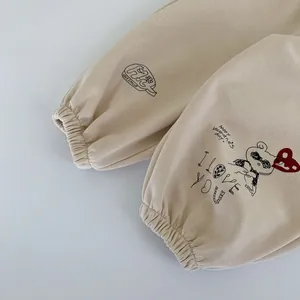 Détail du jogging beige pour enfant avec motifs ours et chevilles élastiquées