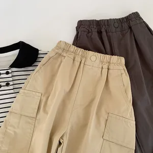 Detail of khaki and grey kids cargo pants featuring elastic waist and utility side pockets