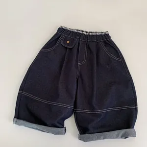 Détail du pantalon en jean bleu foncé pour enfants avec taille élastique et surpiqûres