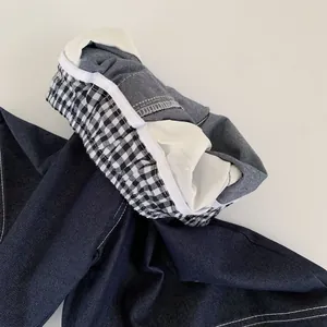 Vue détaillée du jean pour garçon avec doublure vichy noir et blanc et coutures renforcées