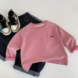 Vista piatta della felpa rosa con ricamo Babysky e pantaloni denim con risvolti a quadri
