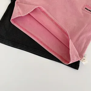Dettaglio dell'orlo a doppia cucitura e dell'etichetta taglia 90 della t-shirt in cotone