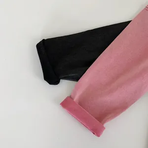 Dettaglio dei polsini in maglia a coste su t-shirt per bambini nero e rosa