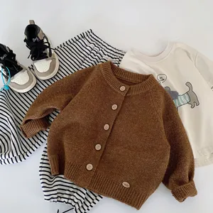 Children knit cardigan outfit with striped pants and cartoon tee in flat lay style