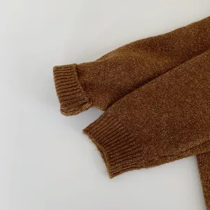 Macro shot of brown knit sweater ribbed cuff showing chunky wool blend texture