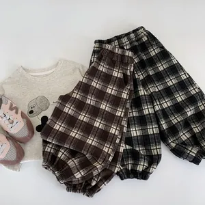 Flat lay of kids plaid joggers set with grey dog print sweatshirt and casual sneakers