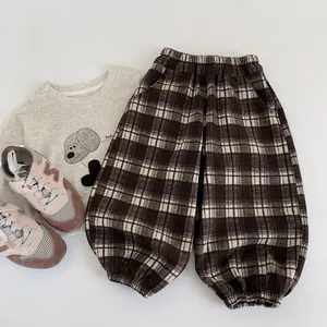 Flat lay of brown checkered toddler pants with elastic waist and gathered cuffs