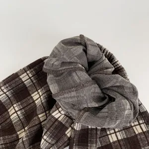 Detail shot of children's brown plaid trousers showing elastic waistband and neat stitching