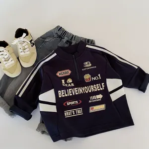 Dettaglio della felpa blu navy da bambino con mezza zip, stampe vintage e strisce