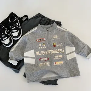 Dettaglio flat lay del set sportivo da 3 pezzi per bambini con felpa stampata e pantaloni