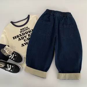 Ensemble trois pièces enfant avec T-shirt crème, jean bleu marine et baskets en toile