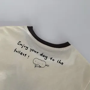 Detail of the cream kid's long-sleeve tee with brown ribbed collar and elephant print
