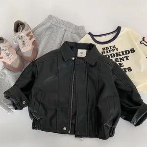 Flat lay of kids faux leather jacket set with grey joggers and white lettered tee