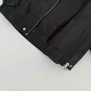 Detail of children's black faux leather jacket featuring silver zippers and elastic hem