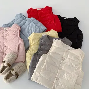 Flachbild von bunten Kinder-Daunenwesten in verschiedenen Farben mit Plüsch-Babyschuhen