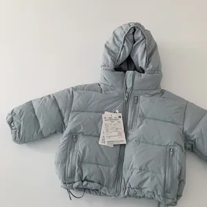 Macro shot of children's down jacket showing zipper pockets and adjustable drawstring hem