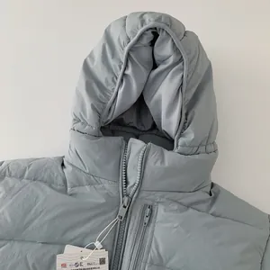 Detail view of children's grey down jacket showing the zipper, hood, and certified product tags