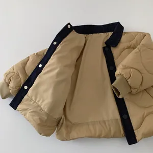Close-up of khaki quilted boys jacket featuring navy denim collar and wave stitching