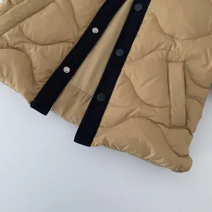 Detail of khaki quilted down jacket with denim trim and silver snap buttons