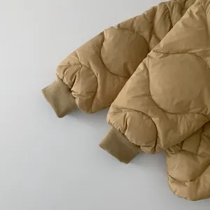 Detail of khaki quilted puffer jacket showing elastic ribbed cuffs and waterproof fabric