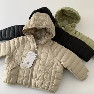 Detailed flat lay of children hooded down jackets in beige, black and olive green colors