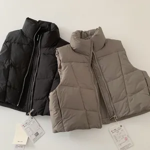 Dettaglio di gilet imbottiti per bambini in nero e kaki con cerniere e trama trapuntata