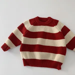 Detailansicht der weichen Stricktextur und des roten Streifenmusters am Kinderpullover