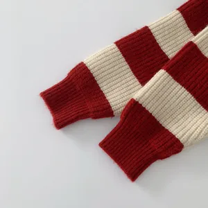 Nahaufnahme der Rippbündchen an einem rot-weiß gestreiften dicken Strickpullover
