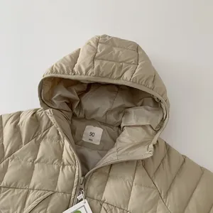 Detail of khaki kids down jacket showing hooded collar and size 90 label on white background