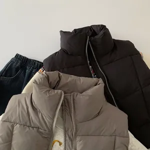 Dettaglio di gilet trapuntati per bambini neri e grigi con collo alto e cerniera metallica