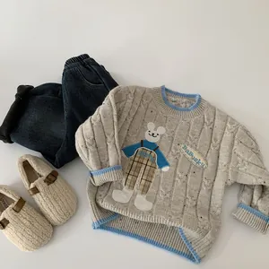 Vue détaillée d'un pull en maille grise pour enfant avec broderie lapin et jean bleu