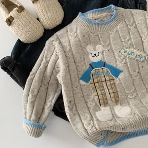 Détail macro du pull en tricot épais pour enfant avec broderie lapin et finitions côtelées