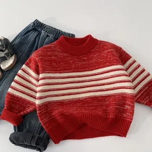 Flat lay of red and white striped kids knit sweater with rib knit cuffs and denim pants