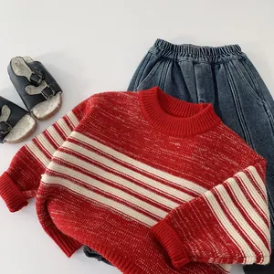 Detailed flat lay of red and white striped kids sweater with ribbed cuffs and blue jeans