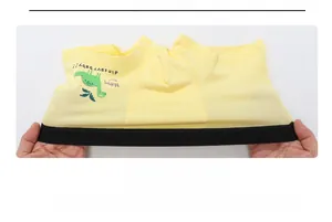 Elasticity test of boys yellow cotton boxer briefs featuring a green dinosaur print
