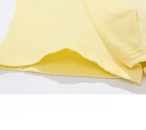 Macro shot of double-stitched hem on soft yellow cotton boxer briefs for boys