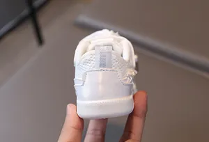 Close-up of white baby sneaker heel featuring breathable mesh and pearl embellishments
