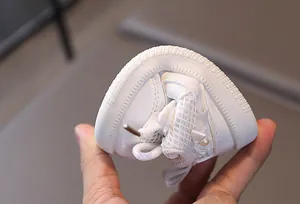 Close-up of flexible white toddler shoe with mesh, bow, and soft non-slip rubber sole
