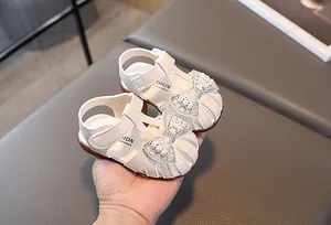 Detail of baby girl sandals with pearl bow, hollow closed toe design and velcro strap