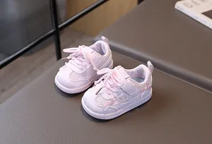Detail of pink baby walking shoes with breathable mesh and cute bow with pearl accents