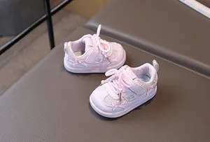Detailed macro view of pink breathable mesh baby shoes with pearl ribbon decoration